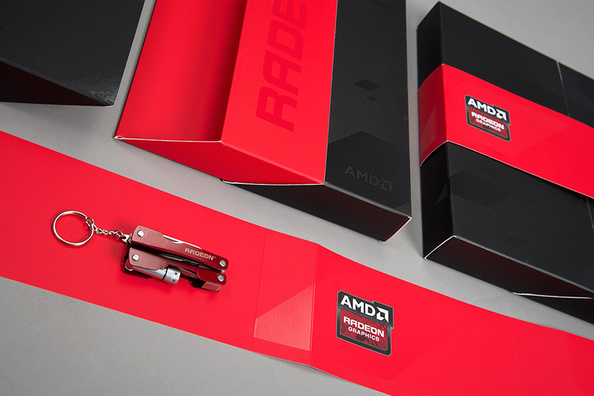 Kitting showing a folded cardboard base, belly band and utility tool with AMD branding